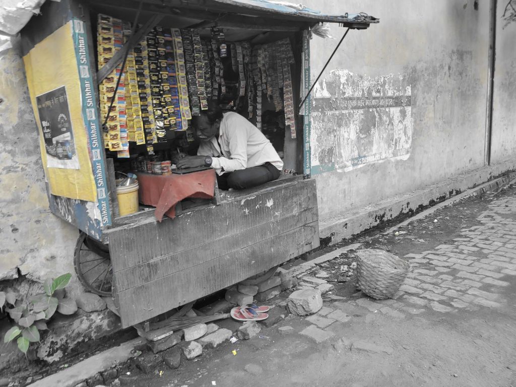man tending his kiosk, India
