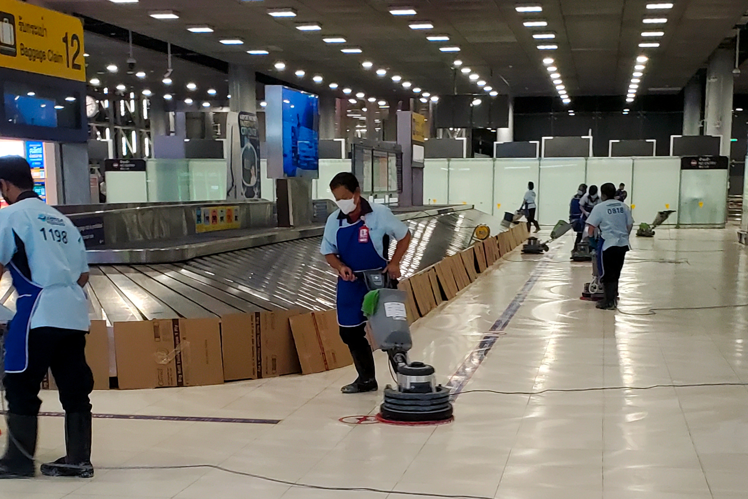 arriving at the airport in Bangkok - a dozen workers were polishing the floor and vacuuming the ceiling at baggage claim
