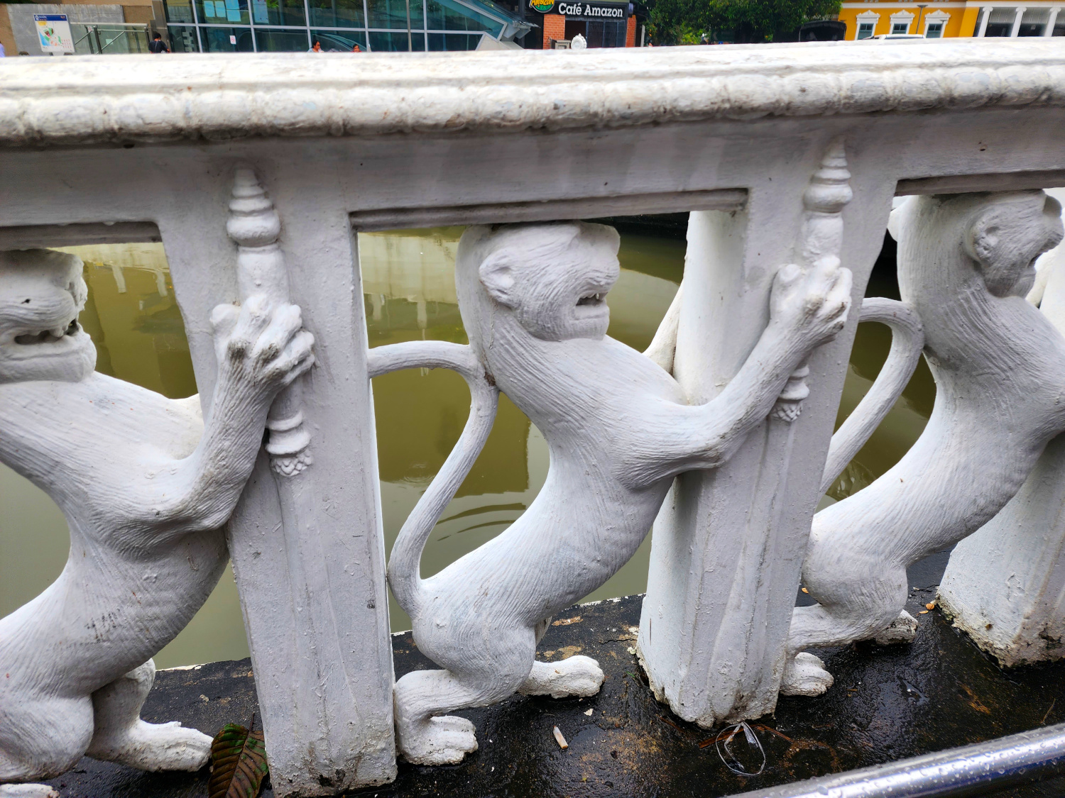 detail photo of 3 lions holding up the rail on a pedestrian bridge. street photography