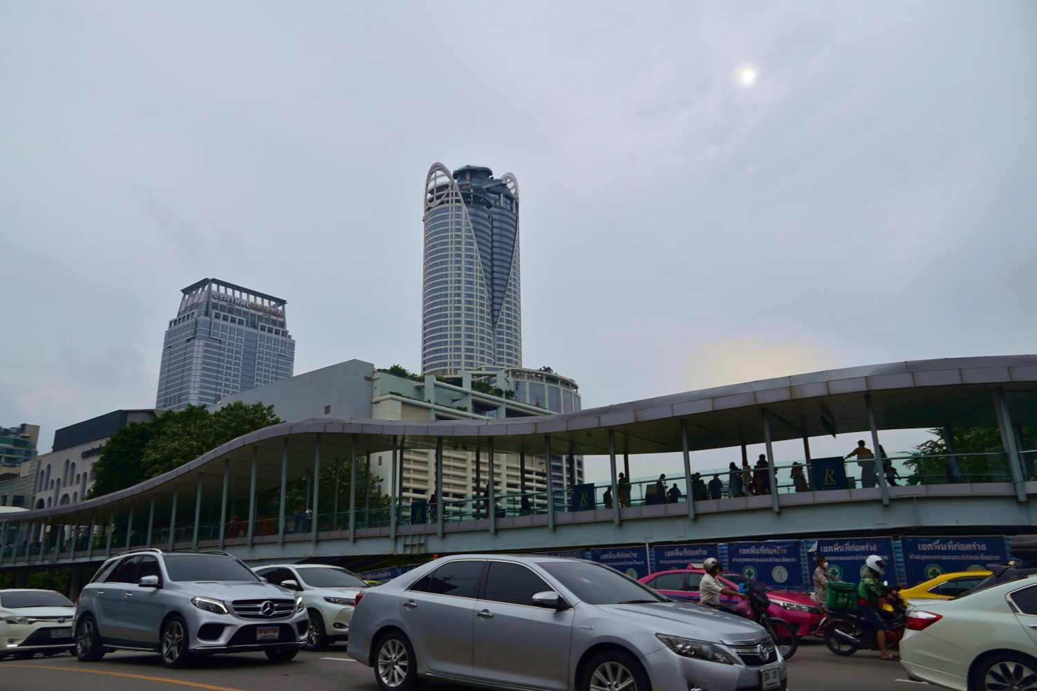 street traffic and pedestrian bridge near shopping centers in Bangkok