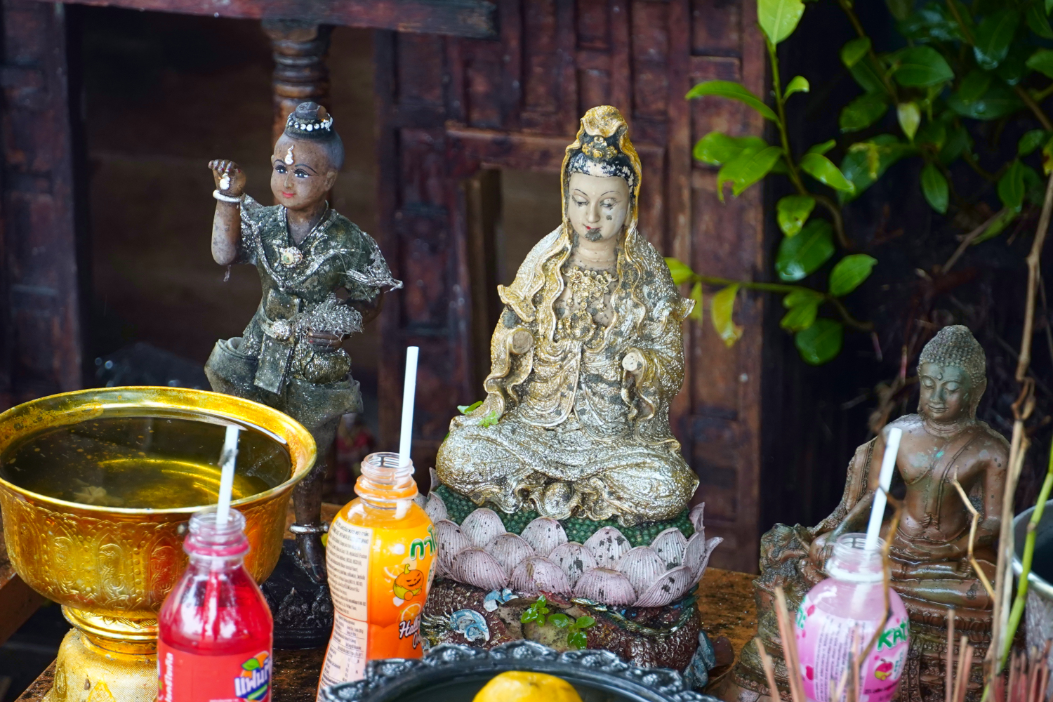 offerings of soda at a shrine along the street in Bangkok