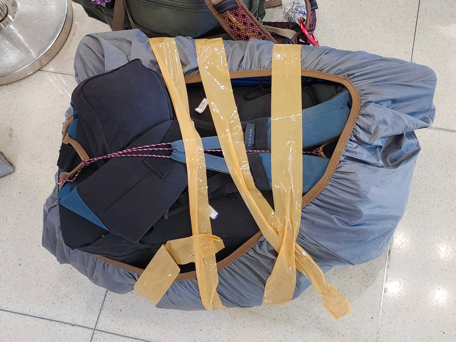securing our backpack cover with packing tape at the airport